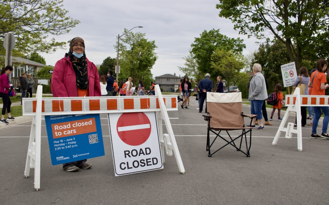 A woman posing in front of a Road Closed sign set up at a School Street