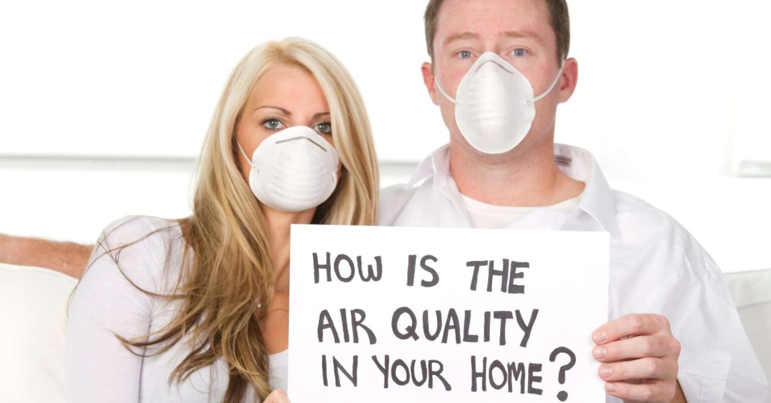 People holding a 'How is the air quality in your home?' placard