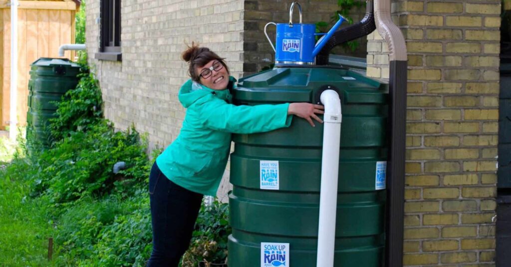 Person hugs a rain barrel
