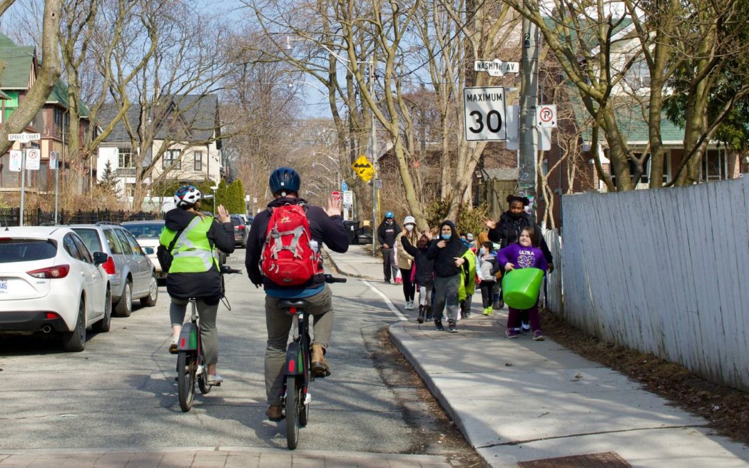 Cyclists waving to student “walking school bus” in Toronto, Ontario (Photo by: Green Communities Canada)