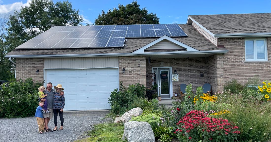 Image of the family in front of the house with solar panels installed