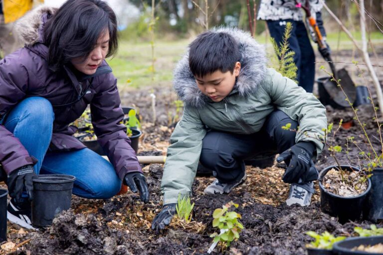 An adult and child planting together