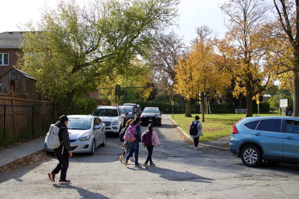Students crossing a congested street on their way to school