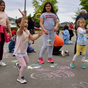 kids playing on pavement covered in sidewalk chalk