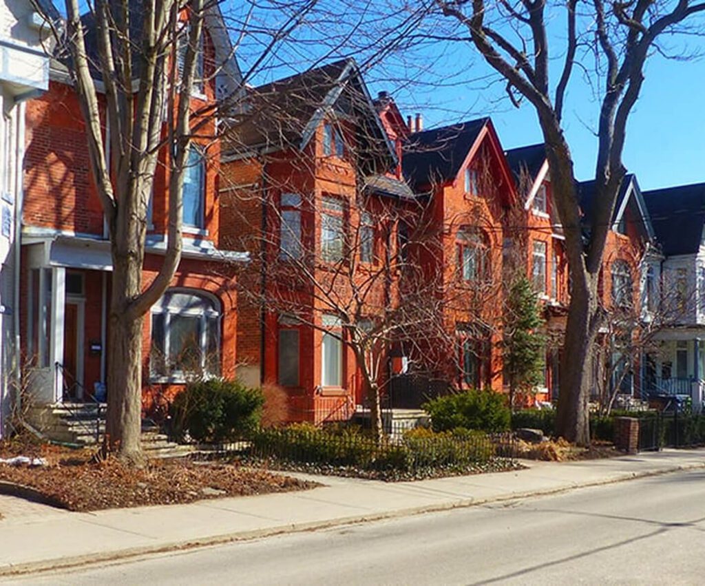 A row of red brick century homes on a residential street