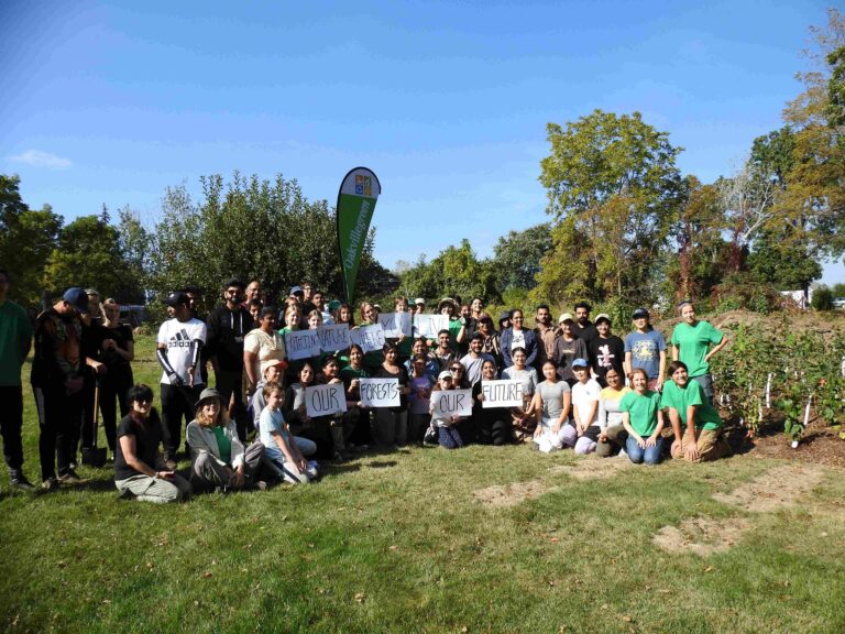Oakvillegreen staff and volunteers planting a mini forest at the Joshua Creek Heritage Arts Centre, just a kilometre north of Buttonbush Woods. The signs say “Protect nature where you live. Our forests. Our future.” (2023, Oakvillegreen)